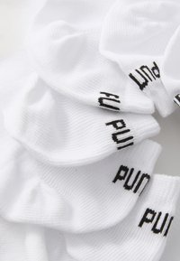 Bijele čarape do članaka s rebrastom teksturom, na manžetama s crnim tekstom "pun". Dizajn je skupljen, prikazujući slojevito tkivo.