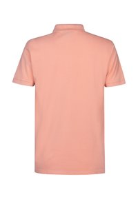 Polo à manches courtes en tissu doux de couleur rose clair. Il présente un col classique et des coutures discrètes le long des manches et de l'ourlet. Design simple.