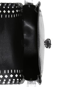 Czarna skórzana torba na ramię widziana z góry, otwarta, ukazująca przestronne wnętrze i srebrną klamrę zapinaną z boku.