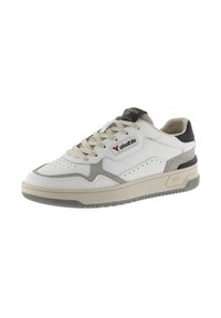 Sneaker in pelle bianca con accenti grigi e neri, design perforato sulla punta, lacci beige, suola texturizzata e dettagli del marchio sulla linguetta.