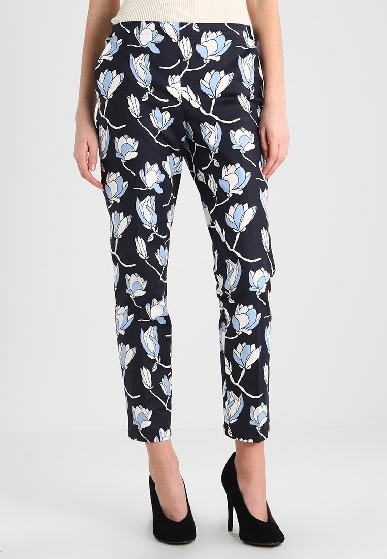 Květinové kalhoty s námořnickým pozadím, s bílým a světle modrým vzorem magnólie. Slim fit, hladká textura a délka ke kotníkům.