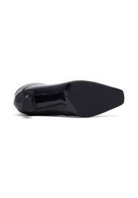 Scarpa nera con tacco alto, punta affusolata e finitura liscia e lucida. Sole piatto con un leggero tacco sul retro, dettaglio minimo.