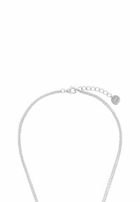 Collana in argento con un design a maglie sottili, dotata di chiusura a moschettone e lunghezza regolabile con un accento di targhetta metallica.
