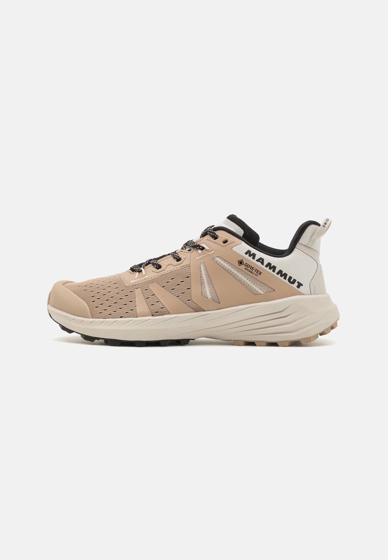 Chaussures de randonnée pour hommes avec une tige en mesh beige, un capuchon renforcé à l'avant, des accents noirs et une semelle robuste pour une traction optimale.