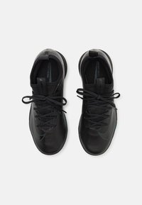 Zapatillas deportivas negras con un upper texturizado, punta redonda y cierres de cordones. Presenta un sutil acento azul y una suela acolchada para mayor comodidad.