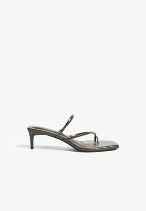 Roheline patendiga nahast kontsaga sandaal, millel on kaks õhukest rihma ja varvaste silmus. Omab ruudukujulist eesosa ja sihvakat 5 cm kontsa.