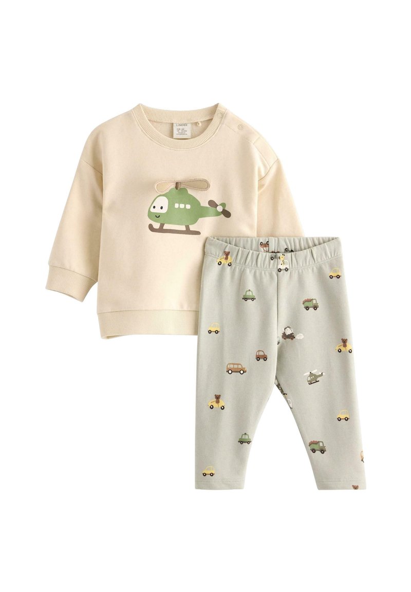 Beżowa bluza z zielonym nadrukiem helikoptera i kremowymi akcentami, zestawiona z jasnobeżowymi legginsami z różnymi ilustracjami pojazdów.