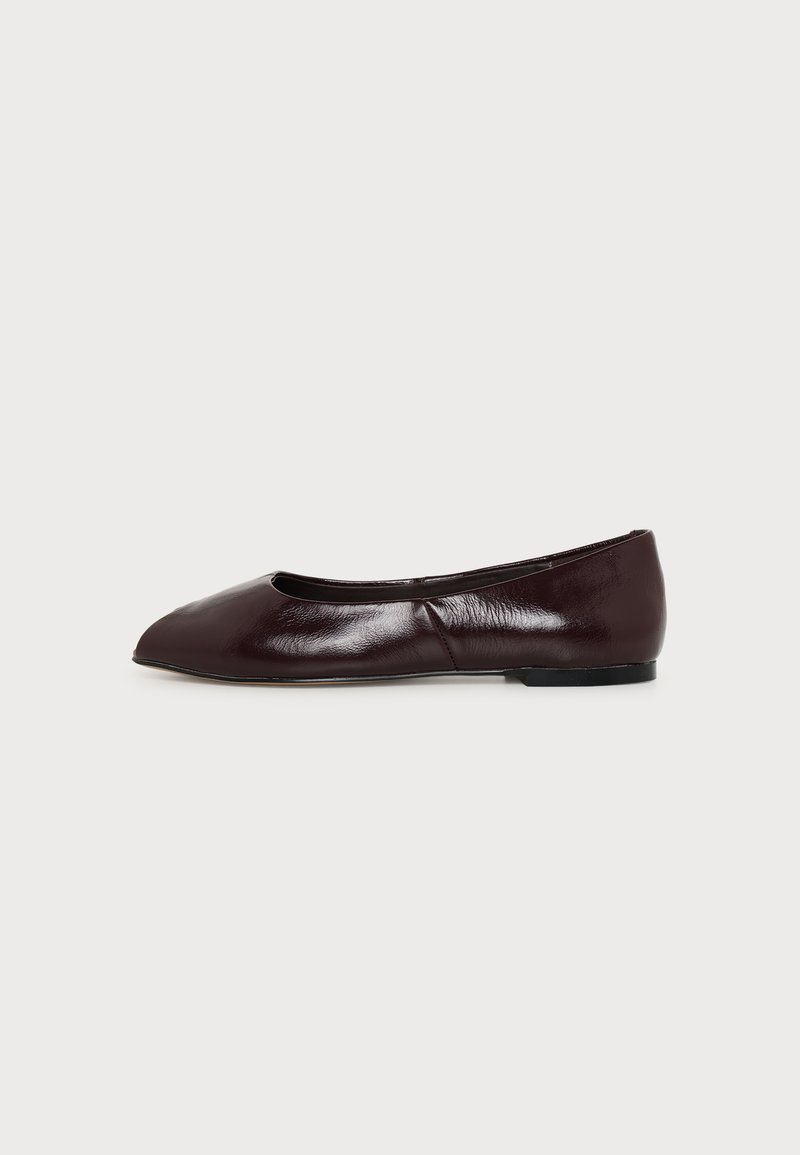 Chaussure plate en cuir marron foncé avec un bout carré arrondi et une semelle basse noire, vue de profil sur fond blanc.