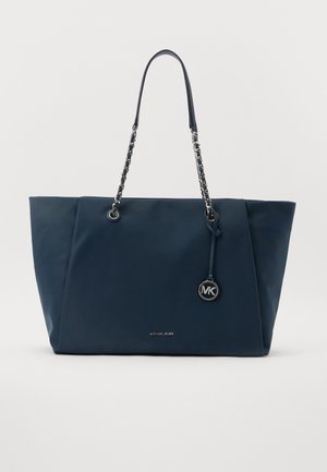 Sac cabas bleu marine avec anses à maillons de chaîne et pendentif logo Michael Kors suspendu sur un côté.