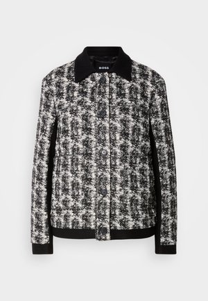 Zwart-wit patroonjacket met een kraag, knoopsluiting en contrasterende manchetten. Gemaakt van textuurstof en heeft een getailleerde pasvorm.