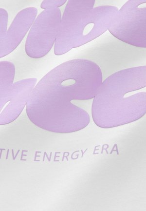 Biela látka s veľkými, hladkými, levanduľovými nápismi „vibe check“ a „pozitívna energetická éra“, vytvára minimalistický dizajn.