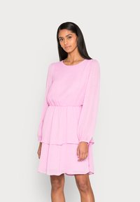 Vestido rosa de mangas longas com decote redondo, design em camadas e padrão de bolinhas subtil. Feito de um tecido leve e fluido.