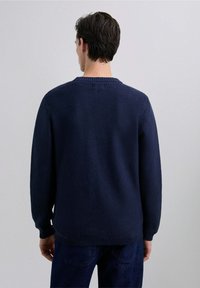 Suéter de punto azul marino con cuello redondo acanalado, que presenta un patrón texturizado y mangas largas, puños rematados y un ajuste relajado.