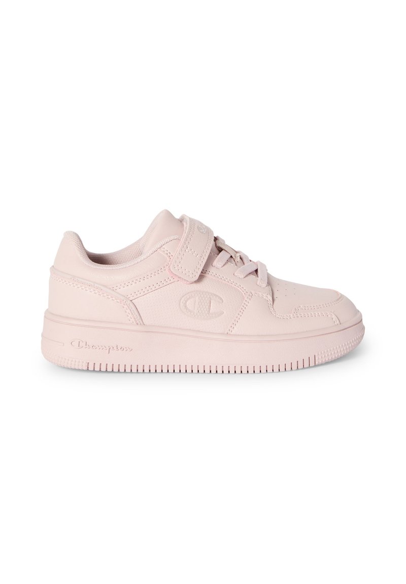 Zapatilla baja de color rosa claro con cordones en el frente y correa de velcro, suela texturizada y logotipo de Champion en relieve en el lateral y la suela.