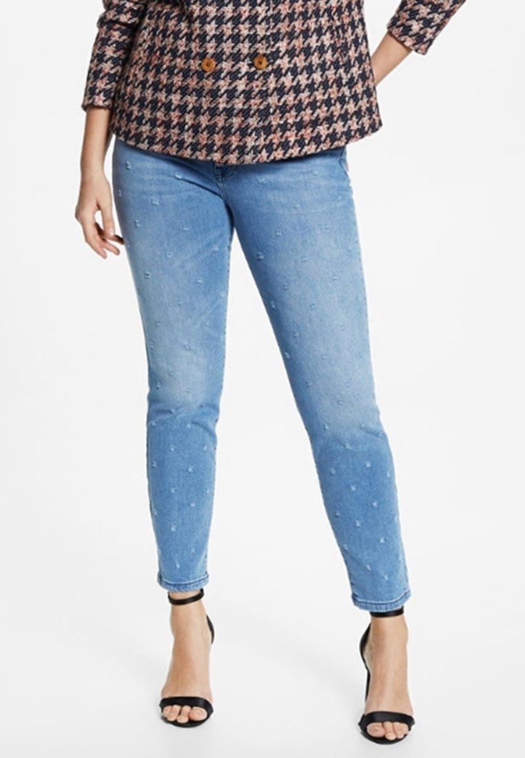 Jeans ajustados de un azul claro con embellishments texturizados. Fabricados en denim con un acabado suave, de longitud hasta el tobillo, combinados con un tacón negro.