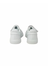 Baskets en cuir blanc avec une texture lisse, design basse et logo "adidas" embossé sur le talon. Elles ont une semelle en caoutchouc plate.