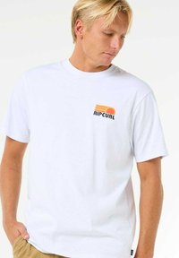 White cotton t-shirt featuring a small multicolored “Ripcurl” logo on the left chest, short sleeves, and a relaxed fit.