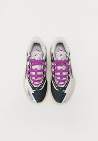 Sportsko sneakers i en blanding af hvide, sorte og lilla farver, teksturerede overlays, lilla snørebånd og et shiny, elegant design.