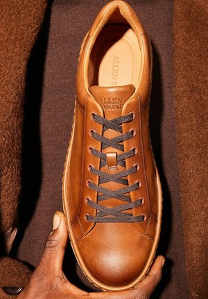 Sneaker in pelle marrone con lacci neri, punta rotonda e finitura liscia. "ALLEN" impresso sulla linguetta, con suola testurizzata e dettagli di cucitura.