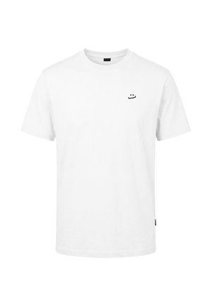 T-shirt blanc à manches courtes avec col rond, orné d'un petit smiley minimaliste noir brodé sur le haut gauche de la poitrine.