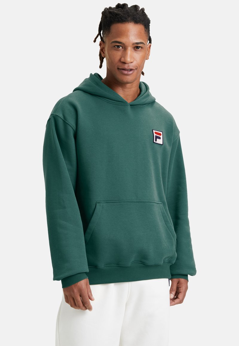 Felpa verde con cappuccio, dotata di tasca frontale, polsini a costine e un piccolo logo rosso e blu sul lato sinistro del petto. Tessuto dalla consistenza liscia.