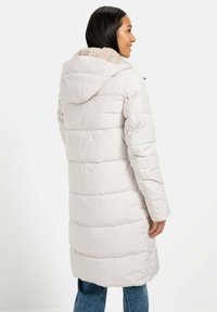 Hellgraue Daunenjacke mit einem strukturierten, beigen Kapuzenfutter, langen Ärmeln und horizontalen Nähten. Sie hat einen lässigen Schnitt und ist knielang.
