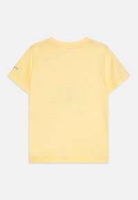 T-shirt jaune à manches courtes en coton, avec un col rond et un design uni. Détail du logo sur la manche gauche.