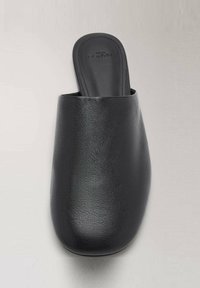 Zapatilla negra sin cordones hecha de cuero texturizado con punta redondeada y plantilla suave, con un diseño minimalista y sin hardware visible.