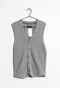 Grå stickad väst med V-ringning, ärmlös design, sex knappar framtill och en hängande etikett. Texturerat tyg.