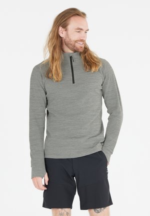 Gray long-sleeve pullover with a zippered collar, textured fabric, paired with black shorts featuring side pockets and a tailored fit.