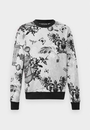 Sweatshirt de gola redonda em preto e branco com padrões florais e de borboletas intrincados, tecido texturizado e punhos e barra pretos.