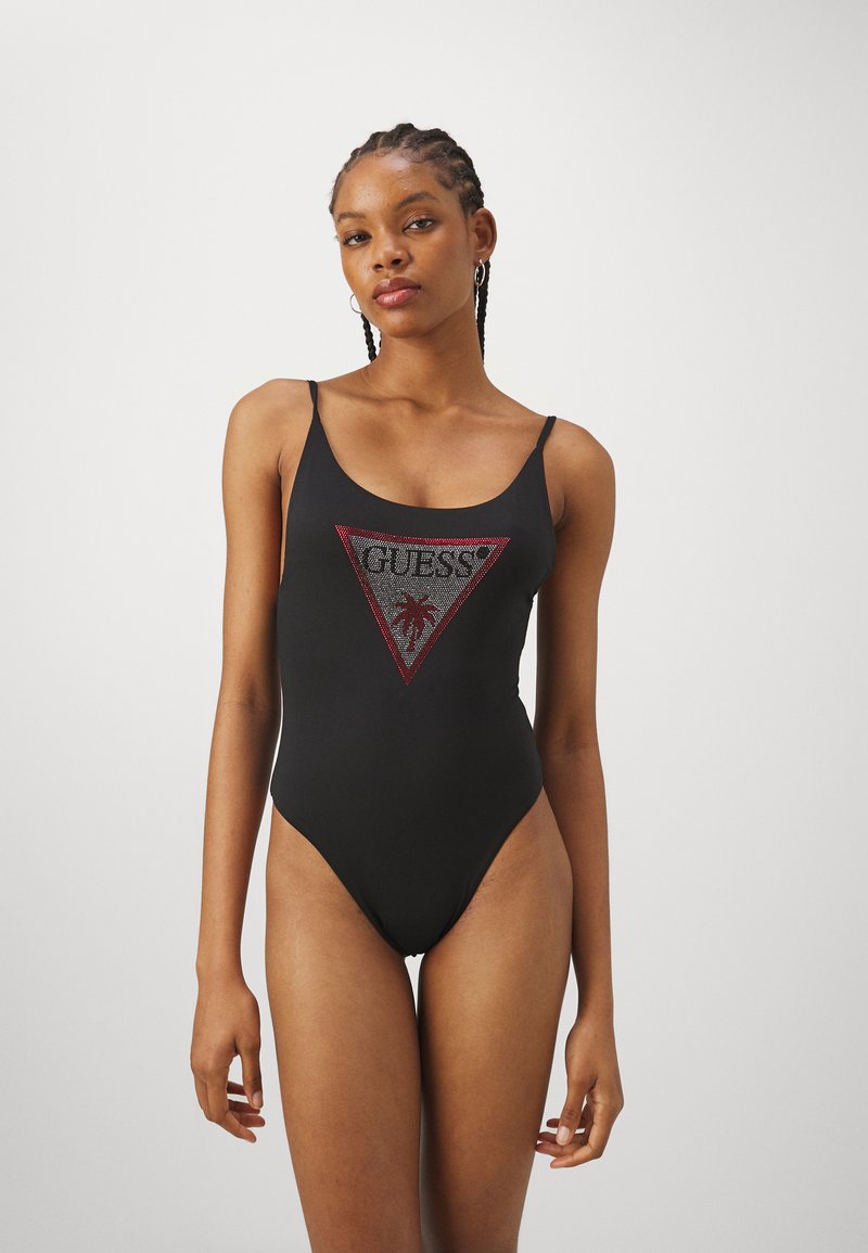 Maillot de bain une pièce noir avec un dos décolleté, présentant un design de logo triangulaire rouge et argenté avec un motif de palmier au centre.