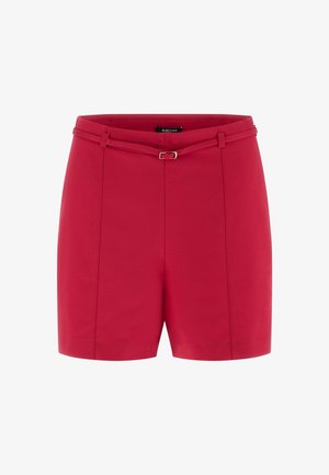 Shorts rouges sur mesure taille haute avec une ceinture assortie fine et une petite boucle dorée, présentant des détails de coutures verticales.