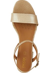 Sandale ouverte beige avec une tige synthétique texturée, une bride lisse et une semelle intérieure rembourrée, comportant une boucle sur la bride de cheville.