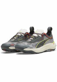 Baskets de sport en maille grise et noire avec des accents rouges et jaunes. Elles possèdent une semelle texturée et des lacets élastiques pour un ajustement sécurisé.