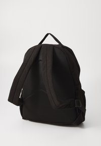 Svart ryggsäck med en strukturerad tygutsida och mesh-bak. Har vadderade remmar och justerbara spännen för komfort och stöd.