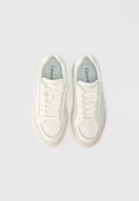 Adidași albi cu un superior din piele texturată, vârf rotund și design cu șireturi. Branding subtil pe limbă, tălpi căptușite și talpă din cauciuc.