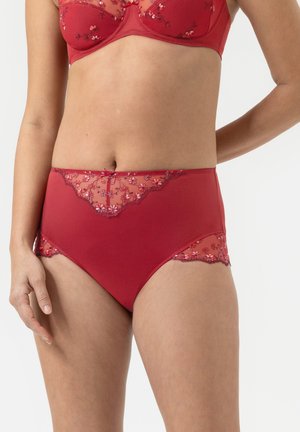 Culotte rouge taille haute avec des panneaux en dentelle transparente et broderies florales à l'avant, bordée de dentelle à volants et avec un petit nœud décoratif.