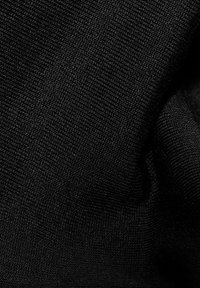 Tessuto lavorato a maglia nero con una superficie fine e texture; mostra pieghe e grinze, enfatizzando la sua natura morbida ed elastica.