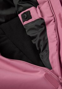 Roze jassen interieur met zwarte fleece voering. Voorzien van een rits, een met knopen sluitende band en contrasterende materialen voor isolatie en comfort.