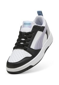 Sneaker bianco e nero con punta perforata, lacci neri e dettagli trasparenti. Presenta una forma arrotondata e una suola robusta in gomma.
