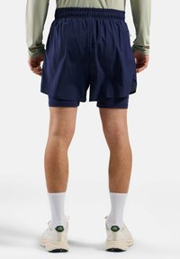 Shorts de sport bleu marine avec une taille élastique, un design superposé et des détails en mesh sur les côtés, associés à des shorts intérieurs ajustés.