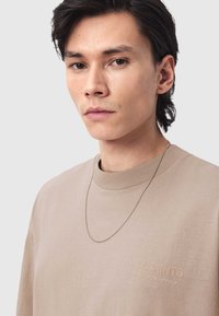 Μπεζ φούτερ με στρογγυλή λαιμόκοψη και ανάγλυφο λογότυπο "ALLSAINTS" στο στήθος, με κοντό ασημένιο αλυσίδα κολιέ. Λείο υλικό.