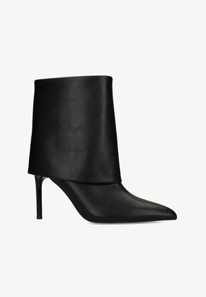 Bottine en cuir noir à talon haut, avec un bout pointu et un large revers plissé autour de la cheville.