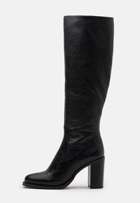 Bota negra hasta la rodilla hecha de cuero texturizado con punta cuadrada y un tacón bloque grueso. Presenta un acabado suave y un diseño minimalista.