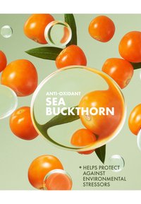 Oranje duindoornbessen en groene bladeren op een lichtgroene achtergrond, met transparante bellen en tekst die de antioxidant eigenschappen benadrukt.