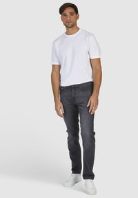 Szare dżinsy o slim fit, w połączeniu z gładką białą koszulką z bawełny i białymi sneakersami. Prosty design bez wzorów i widocznych elementów metalowych.