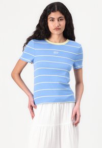 Camiseta de manga corta azul de canalé con rayas horizontales blancas y amarillas y un cuello redondo. Presenta el logo "GAP" en blanco en el frente.