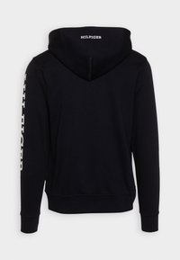 Sweat-shirt à capuche noir avec le texte blanc "HILFIGER" au dos et sur la manche gauche. Fabriqué en tissu doux avec des poignets et un ourlet côtelés.
