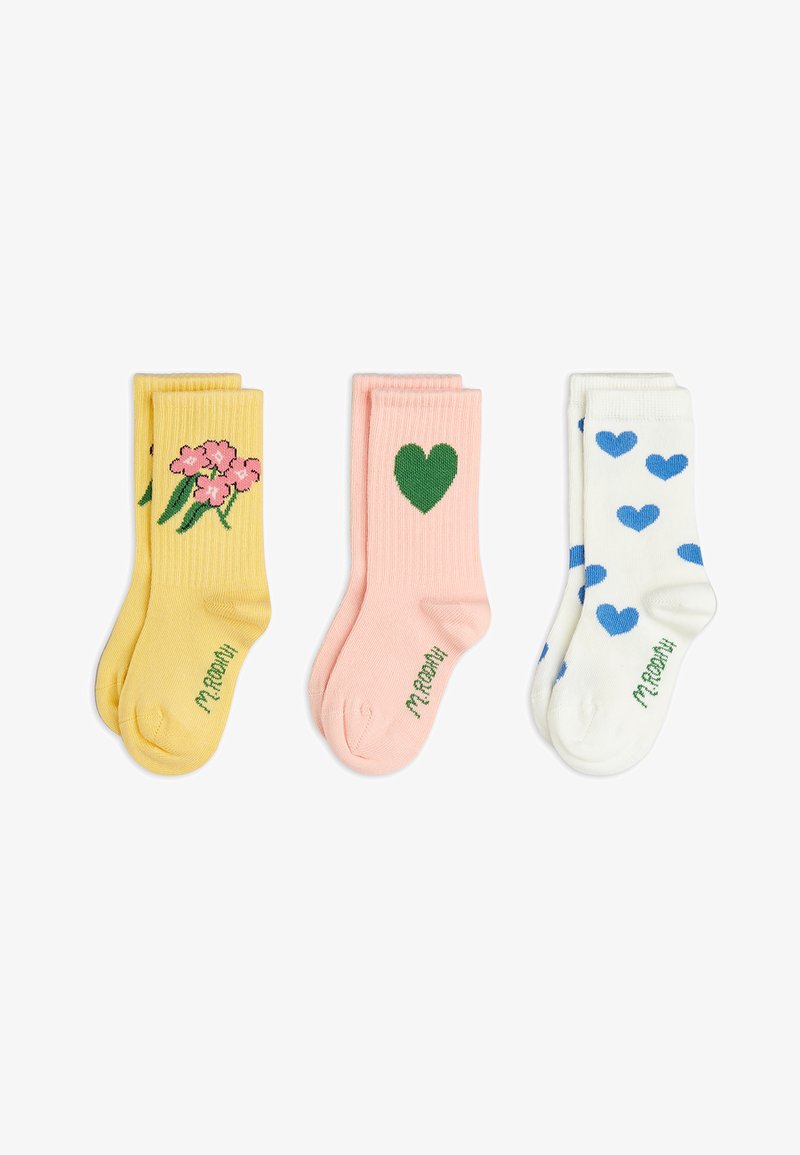 Trzy pary złożonych skarpetek: żółte w różowe kwiaty, jasnoróżowe z zielonym sercem oraz białe w niebieskie serca, każda z napisem "M. ROOM".